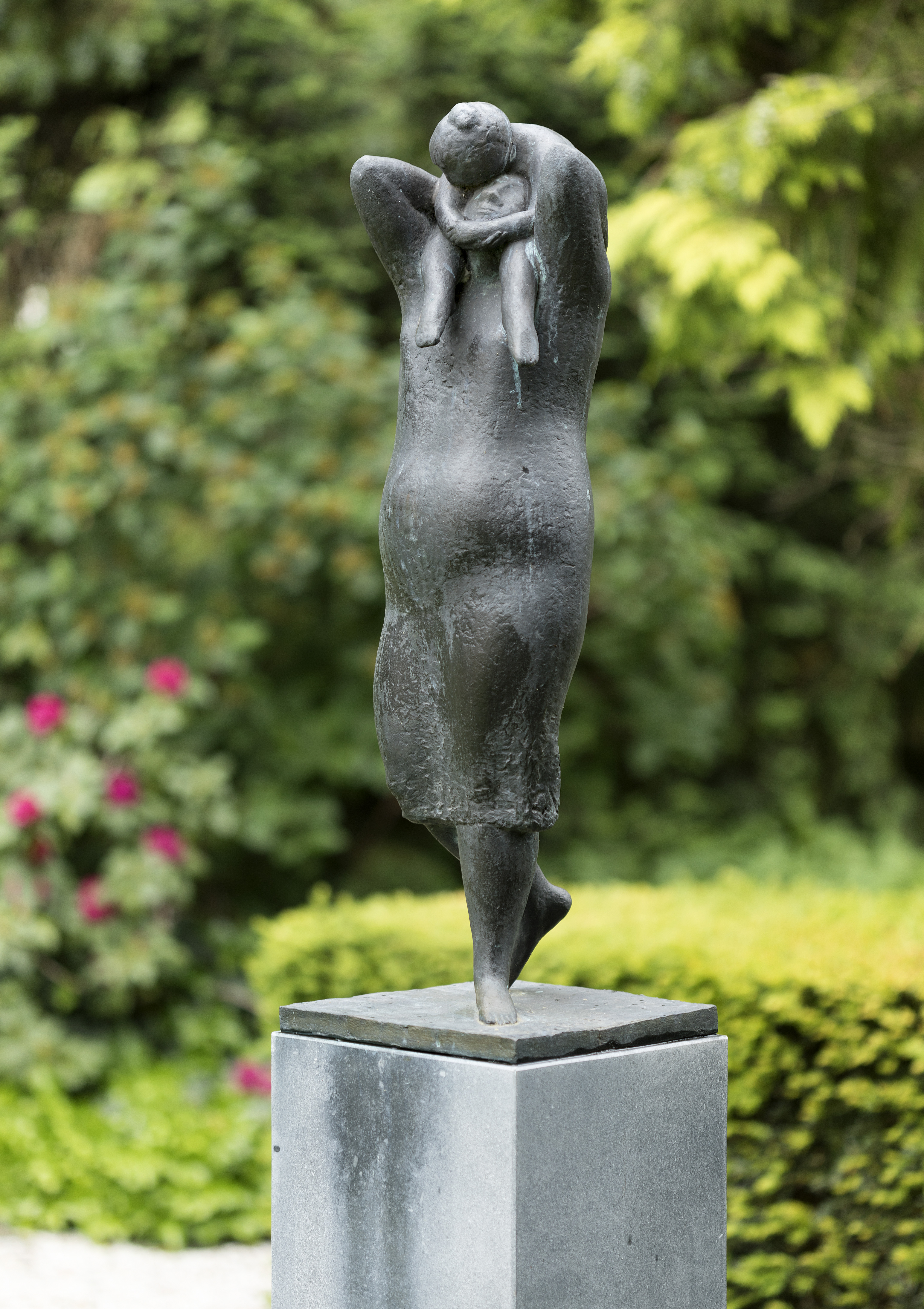 bronzen beeld van moeder met kind op de schouders